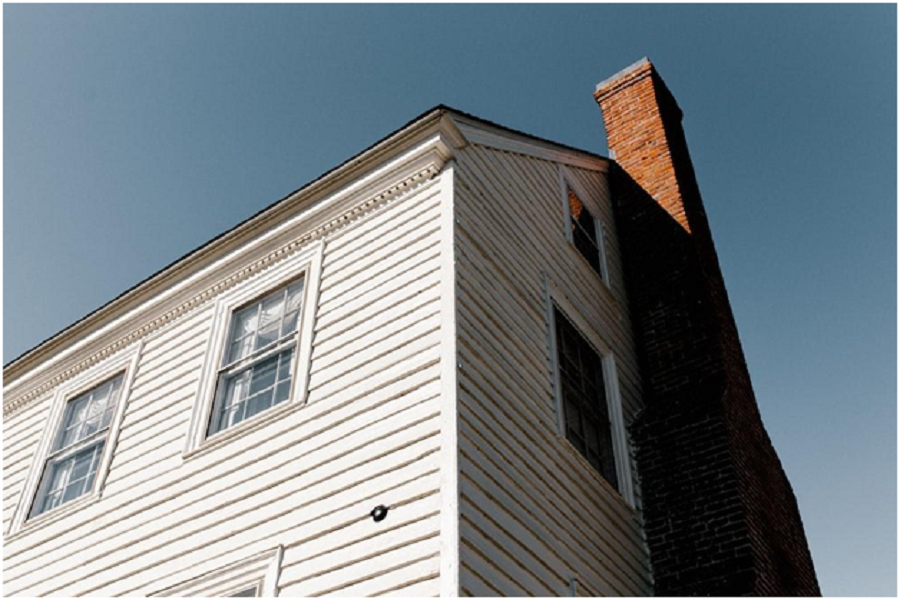 white brick house with a brown colored chimney. 