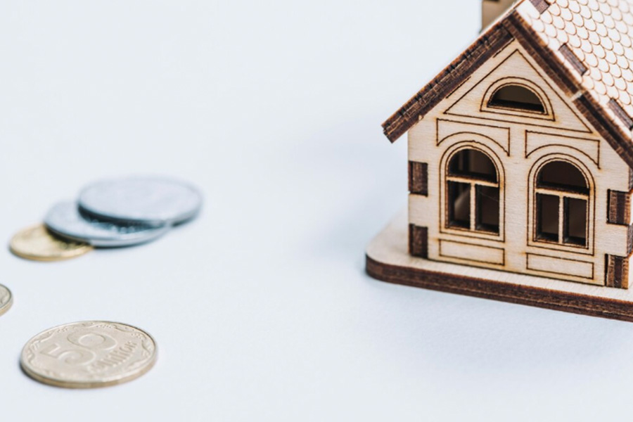 Miniature House Next To Coins
